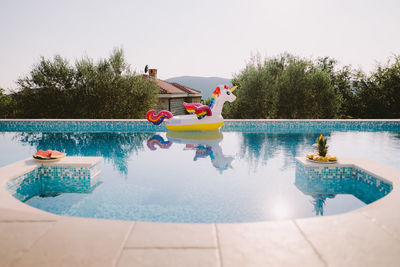 Boats in swimming pool by lake against sky