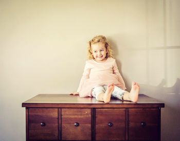 Cute baby girl sitting on sofa