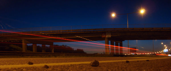 Illuminated bridge against sky at night