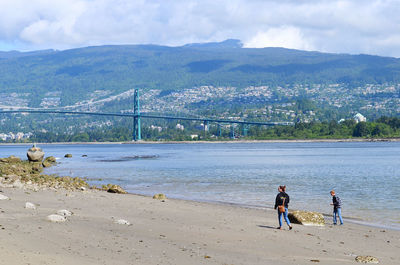 People at beach against sky