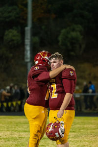 Side view of emotional football players hugging