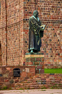 Low angle view of statue against brick wall