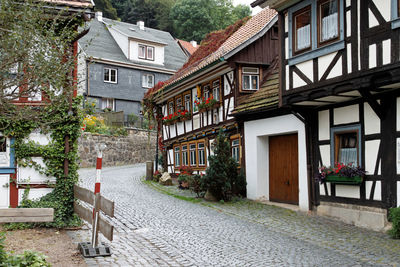 Empty footpath amidst buildings in city