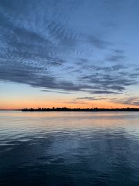 Scenic view of sea against dramatic sky during sunset