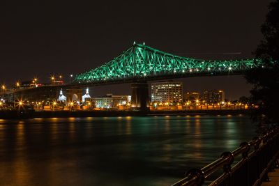 Illuminated bridge over river at night