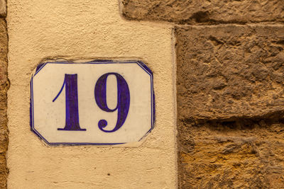 Close-up of number 19 on yellow wall