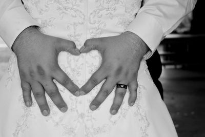 Midsection of couple holding heart shape