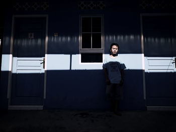 Portrait of man standing against wall