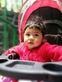 Close-up portrait of baby girl in stroller