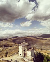 Church on building by mountain against sky