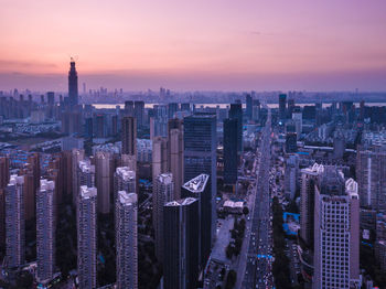 Aerial view of city lit up at sunset