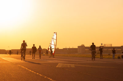 People walking on road in city against clear sky