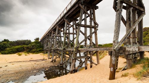 Metallic structure on shore against sky