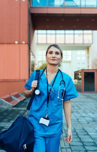Portrait of smiling female doctor standing in city