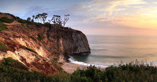 Scenic view of rock formations on sea against sky