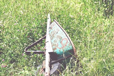 Abandoned rusty wheel on field