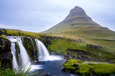 Scenic view of waterfall against sky