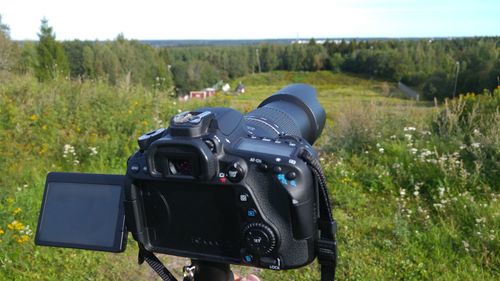 Close-up of camera on field against sky