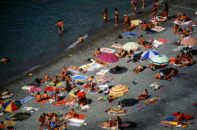 High angle view of people resting by parasols at beach