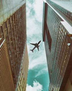 Low angle view of airplane flying over building