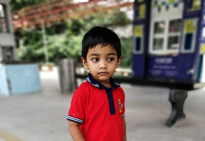 Thoughtful boy standing on railroad station