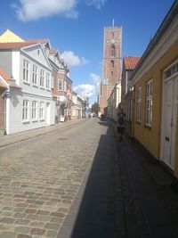 Street amidst buildings in town against sky