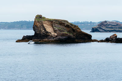 Rock formation in sea against sky