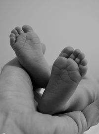 Low section of mother with baby against white background