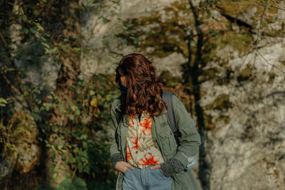 Woman standing by tree in forest during autumn