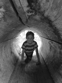 Portrait of boy crawling on wood