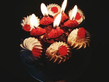 High angle view of illuminated candles on black background