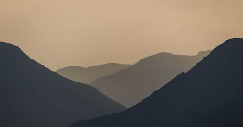 Scenic view of silhouette mountains against sky at sunset