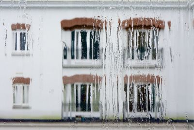 Close-up of icicles on wet window of building