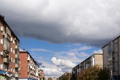 Low angle view of buildings against cloudy sky