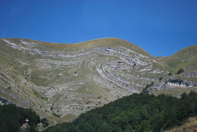 Scenic view of mountains against blue sky
