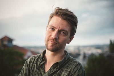 Portrait of mid adult man against cloudy sky