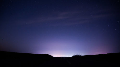 Low angle view of silhouette landscape against sky at night