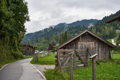 House amidst trees and houses against sky