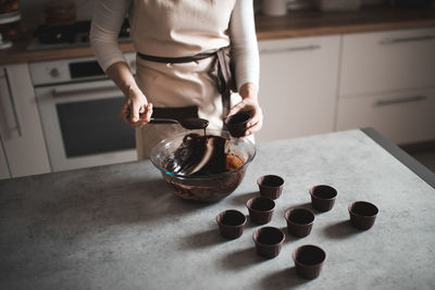 Woman making chocolate batter for muffins at home in kitchen closeup. selective focus. top view.