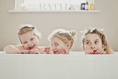 Portrait of cute siblings in bathtub at home