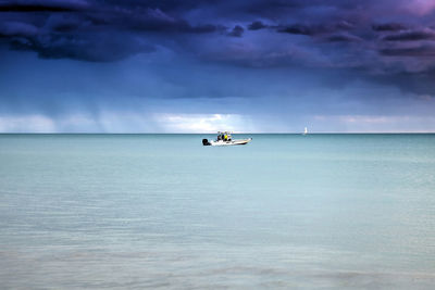 Fishing boat on blue water with rain coming up behind from marco island, florida.