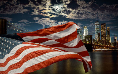 Low angle view of flag amidst buildings in city against sky