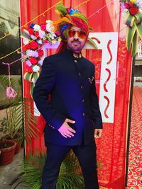 Portrait of young man standing against multi colored wall