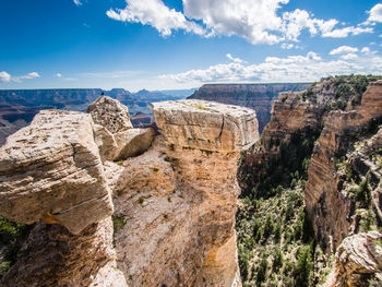 Rock formations on landscape against cloudy sky