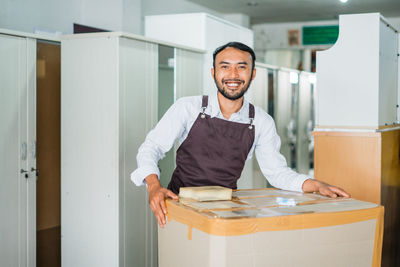 Portrait of smiling young woman standing in office