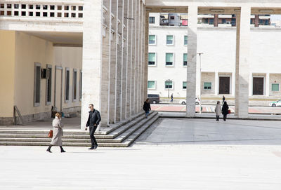 People walking on building in city