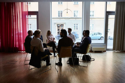 Male and female entrepreneurs sitting in circle at workplace