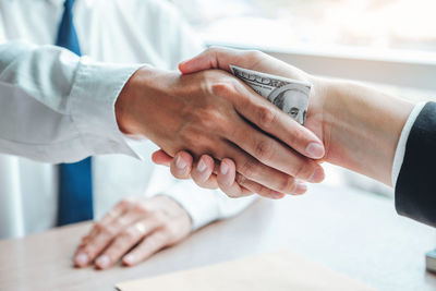 Midsection of couple holding hands