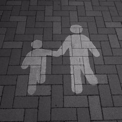 High angle view of pedestrian road sign on cobbled street