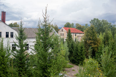 Houses amidst trees and buildings against sky